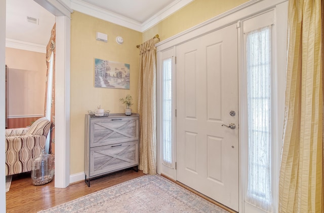 foyer entrance with light wood-type flooring and crown molding