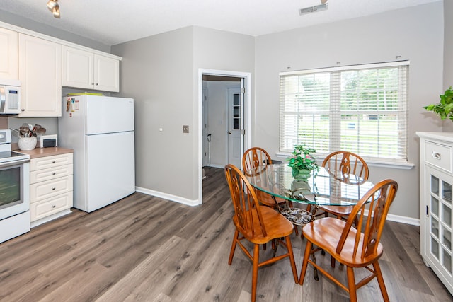 dining area featuring a textured ceiling and dark hardwood / wood-style floors