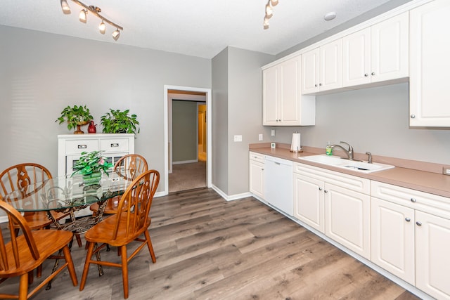 kitchen with light wood-type flooring, a textured ceiling, sink, white cabinets, and white dishwasher