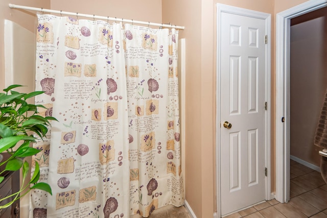 bathroom with walk in shower and tile patterned flooring