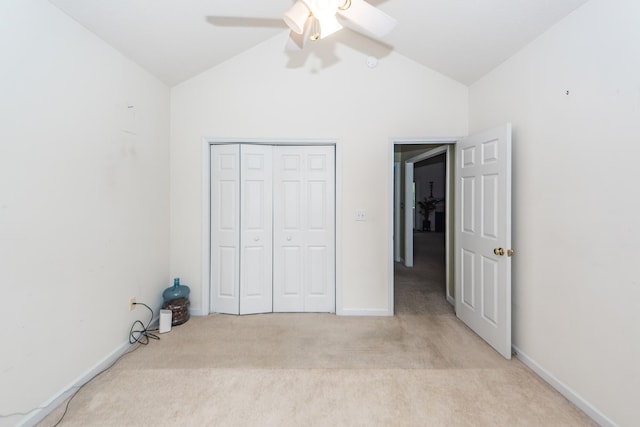 unfurnished bedroom with light carpet, a closet, ceiling fan, and high vaulted ceiling