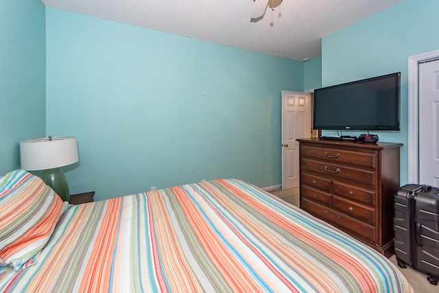 carpeted bedroom with ceiling fan and a textured ceiling