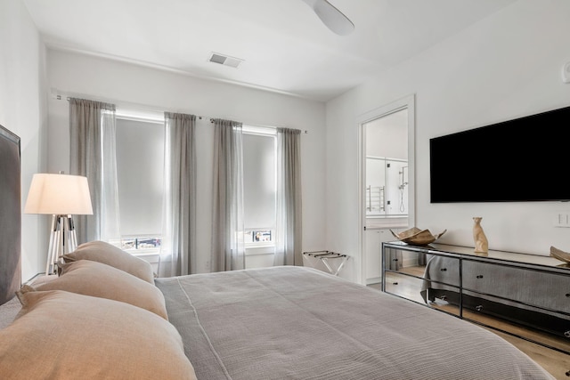 bedroom featuring ensuite bathroom, ceiling fan, and visible vents