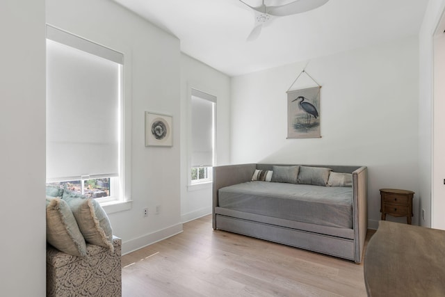 bedroom featuring light wood-type flooring, baseboards, and a ceiling fan