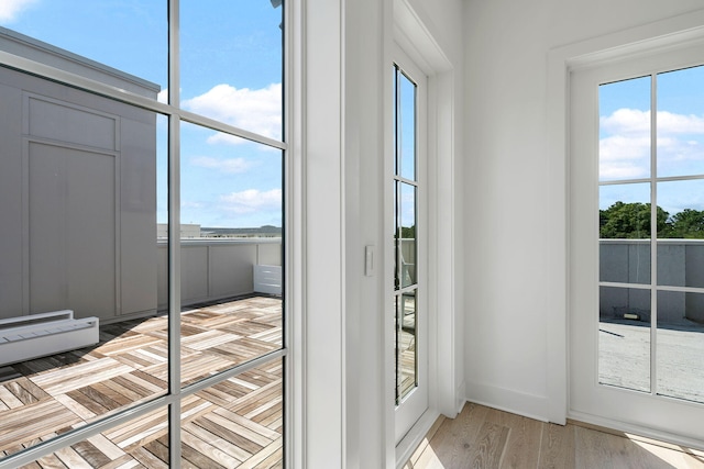 doorway featuring light wood-type flooring and baseboards