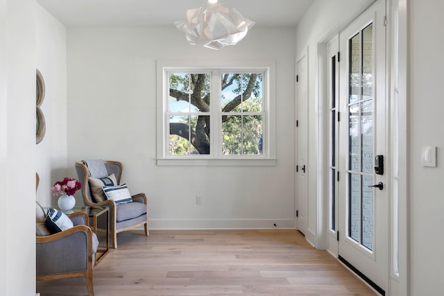 living area featuring light wood-style floors and baseboards