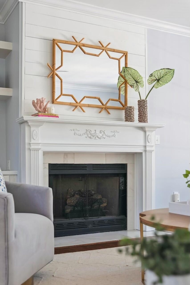 room details featuring built in shelves, a tile fireplace, and crown molding