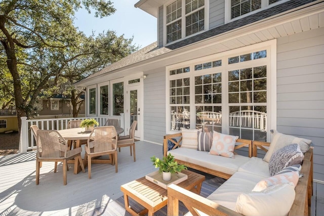 wooden terrace featuring outdoor dining area and an outdoor hangout area