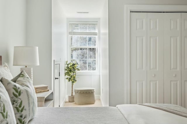 bedroom with a closet, visible vents, and baseboards