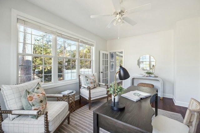 living area featuring ceiling fan, dark wood-type flooring, a sunroom, and baseboards