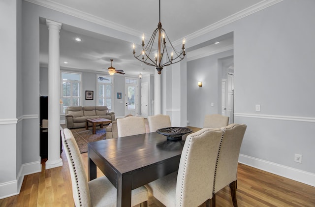 dining space with baseboards, ornamental molding, recessed lighting, wood finished floors, and ceiling fan with notable chandelier