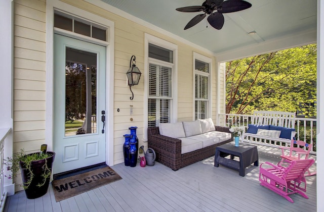 view of exterior entry with a deck, outdoor lounge area, and ceiling fan