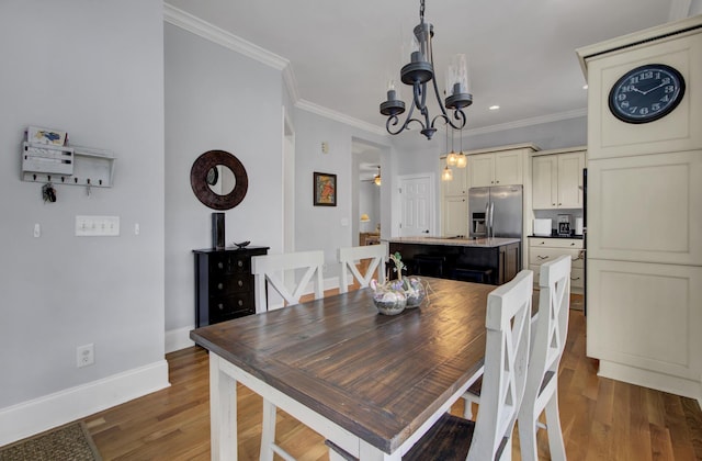 dining area featuring crown molding, baseboards, and wood finished floors