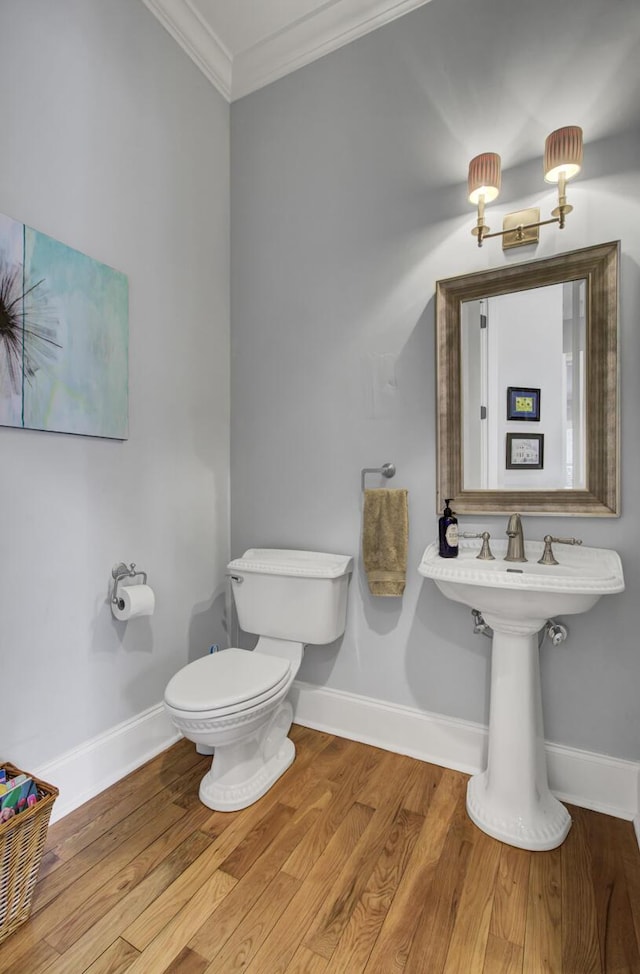 bathroom with wood finished floors, baseboards, and ornamental molding