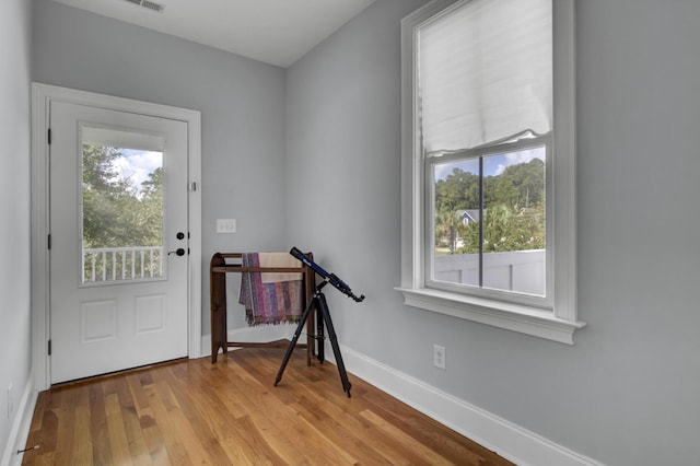 foyer featuring light wood-type flooring, baseboards, and visible vents