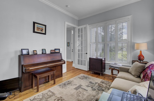 living area with french doors, baseboards, crown molding, and wood finished floors