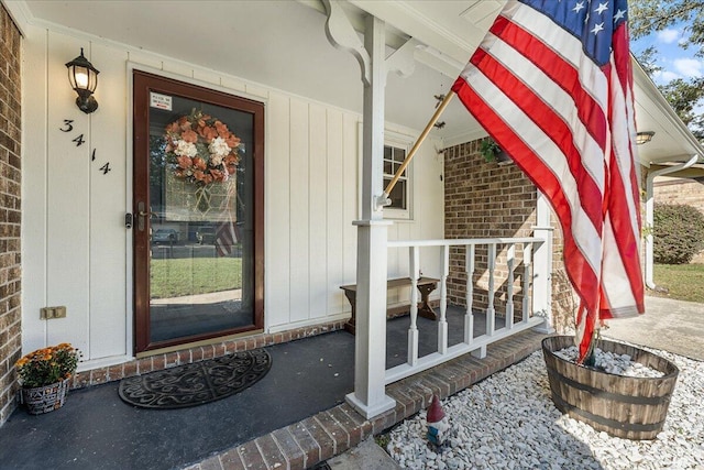 view of exterior entry featuring covered porch