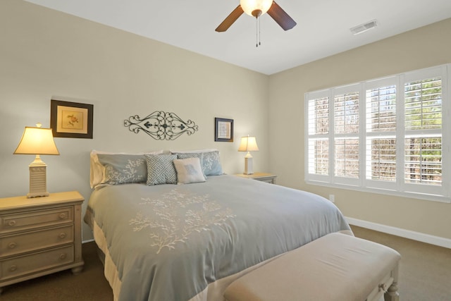 bedroom with visible vents, dark carpet, a ceiling fan, and baseboards