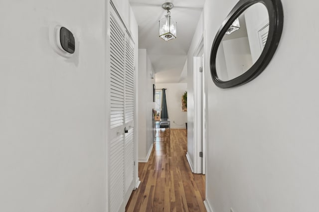 corridor with baseboards and wood finished floors