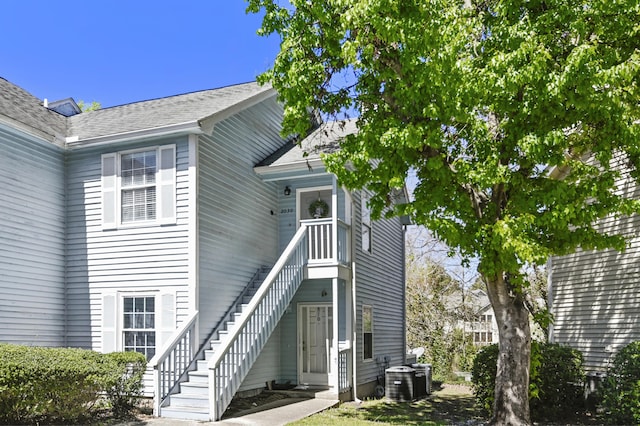 property entrance featuring roof with shingles