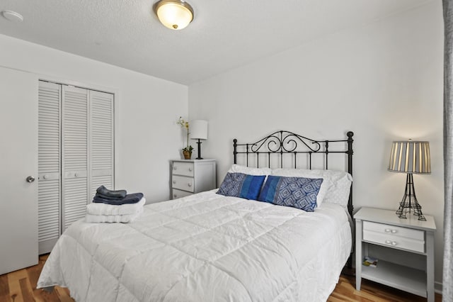 bedroom with a closet, a textured ceiling, and wood finished floors