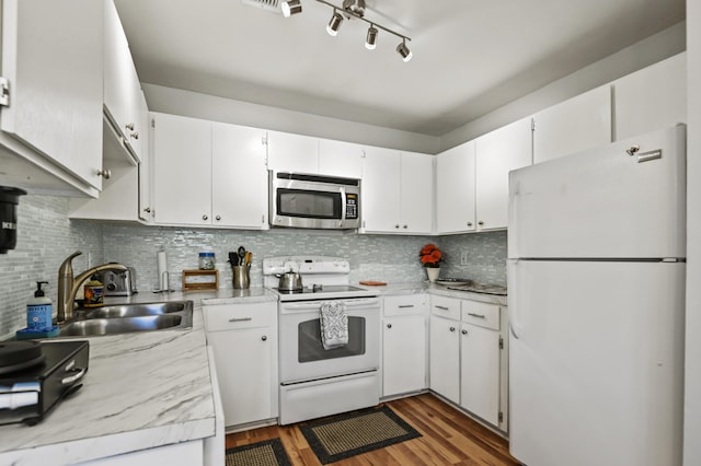kitchen with decorative backsplash, white appliances, light countertops, a sink, and light wood-style flooring