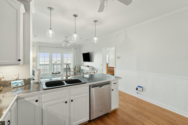 kitchen featuring crown molding, light wood finished floors, stainless steel dishwasher, a sink, and a peninsula