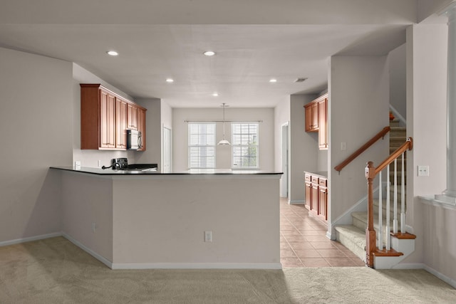 kitchen featuring pendant lighting, light carpet, and kitchen peninsula