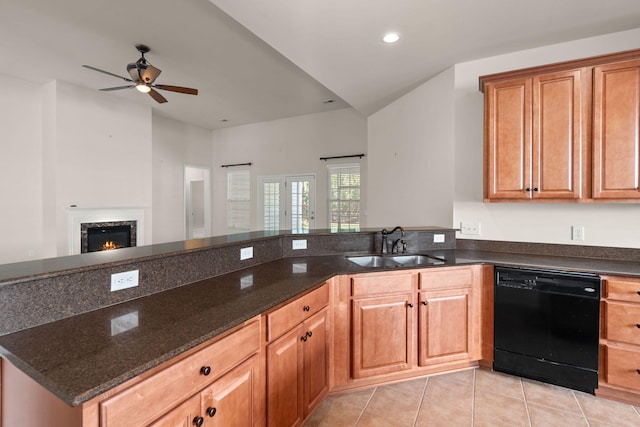 kitchen featuring sink, light tile patterned floors, dishwasher, kitchen peninsula, and dark stone counters