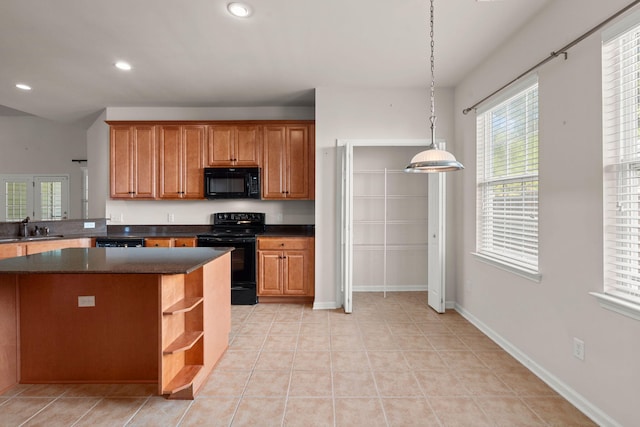 kitchen featuring decorative light fixtures, black appliances, sink, light tile patterned floors, and kitchen peninsula