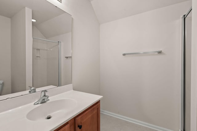 bathroom featuring lofted ceiling, tile patterned flooring, vanity, toilet, and walk in shower