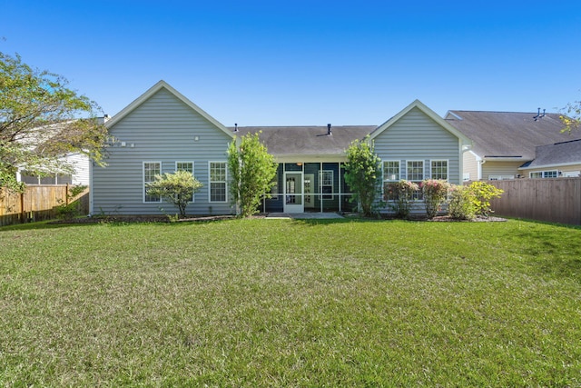 back of house featuring a yard and a sunroom