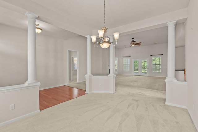 interior space with light carpet, decorative columns, and ceiling fan