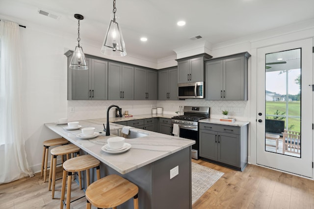 kitchen featuring gray cabinetry, visible vents, appliances with stainless steel finishes, and a sink