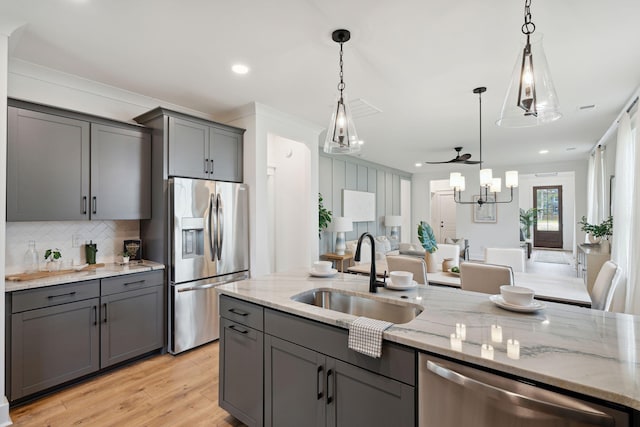 kitchen with gray cabinetry, backsplash, appliances with stainless steel finishes, and a sink