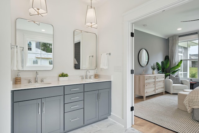 full bath with double vanity, a sink, and a healthy amount of sunlight