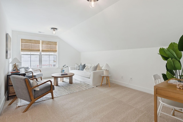 living room featuring baseboards, light carpet, and vaulted ceiling