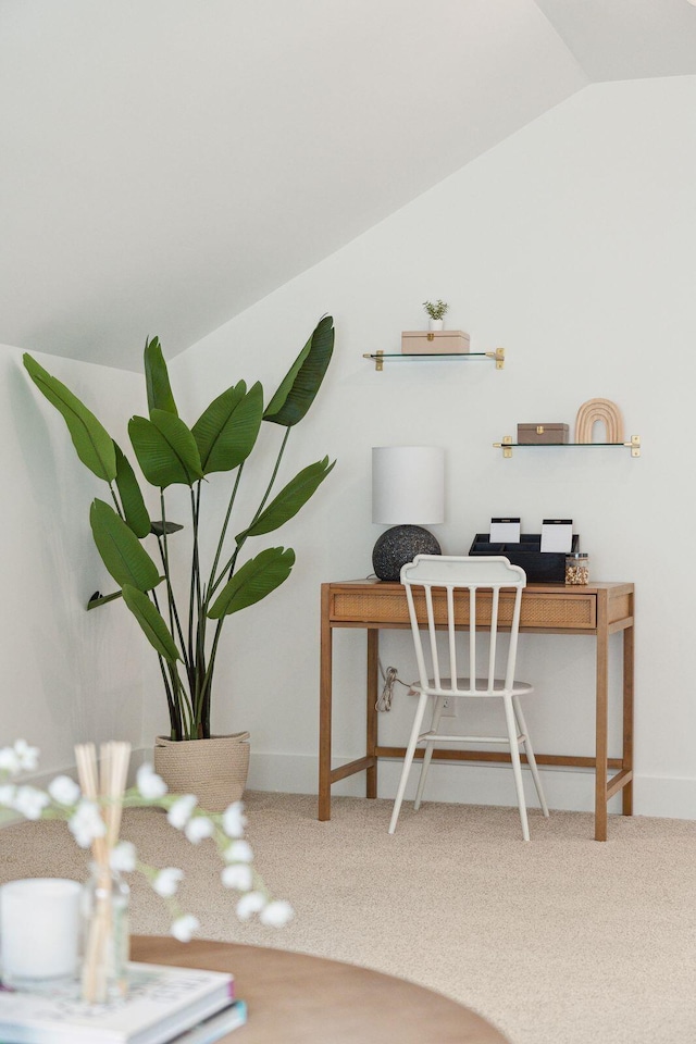 carpeted home office with baseboards and vaulted ceiling