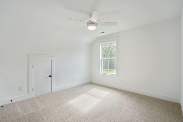 additional living space with a ceiling fan, vaulted ceiling, light colored carpet, and baseboards