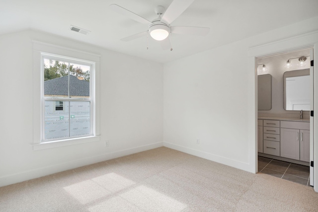unfurnished bedroom with connected bathroom, a sink, visible vents, baseboards, and carpet