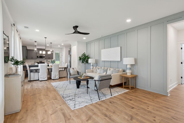 living area featuring visible vents, ceiling fan, recessed lighting, and light wood finished floors