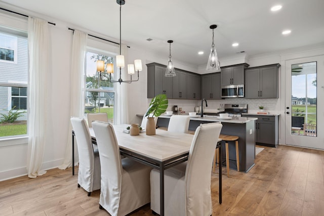 dining space with light wood-style flooring, visible vents, a chandelier, baseboards, and recessed lighting