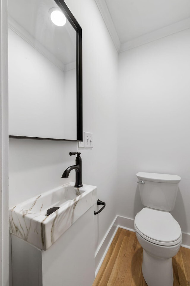1019 Royalist Rd, Mount Pleasant, SC 29464 - half bathroom with ornamental molding, wood finished floors, toilet, vanity, and baseboards