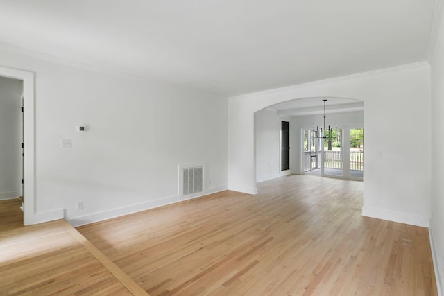 1019 Royalist Rd, Mount Pleasant, SC 29464 - spare room with crown molding, arched walkways, baseboards, light wood-type flooring, and a chandelier