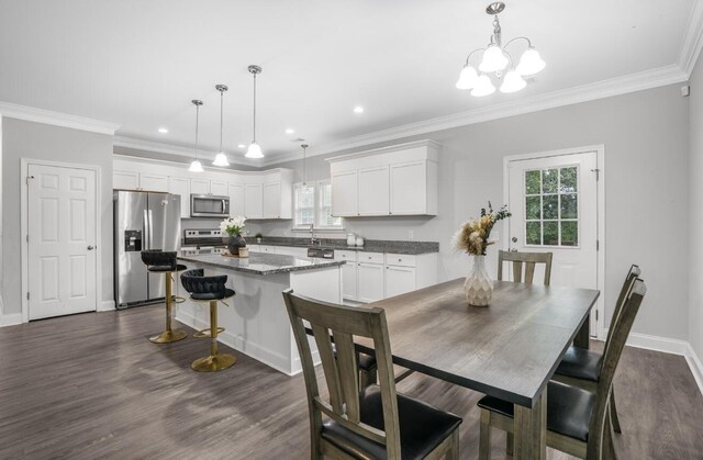 dining area featuring crown molding, dark wood-type flooring, and a chandelier