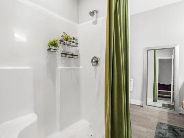 bathroom featuring wood-type flooring and walk in shower