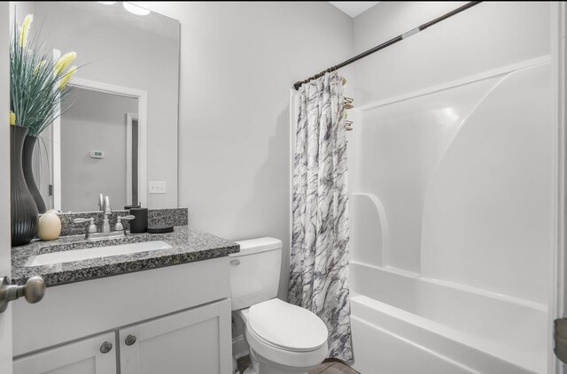 full bathroom featuring shower / bath combination with curtain, vanity, and toilet