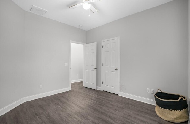 unfurnished bedroom featuring dark wood-type flooring and ceiling fan