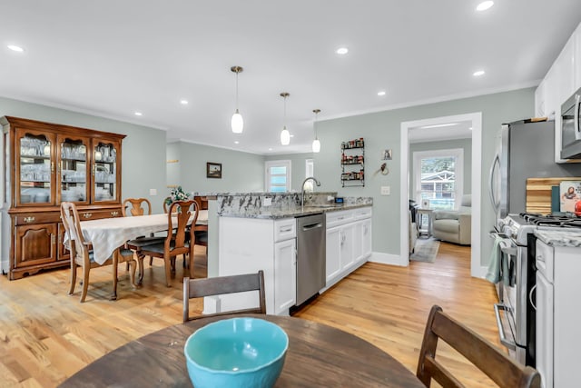 1416 Glencoe Dr, Mount Pleasant, SC 29464 - kitchen featuring appliances with stainless steel finishes, light wood finished floors, white cabinets, a sink, and a peninsula