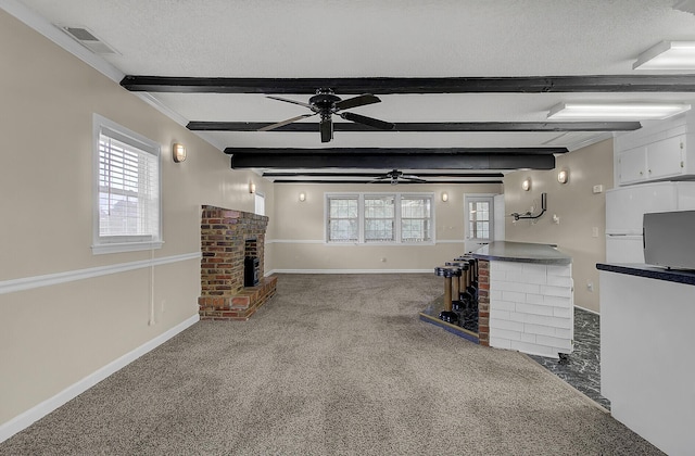 unfurnished living room featuring ceiling fan, beam ceiling, and carpet floors